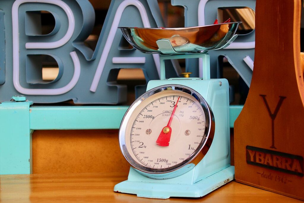 Close-up of a vintage blue kitchen scale with fruits in a modern setting.